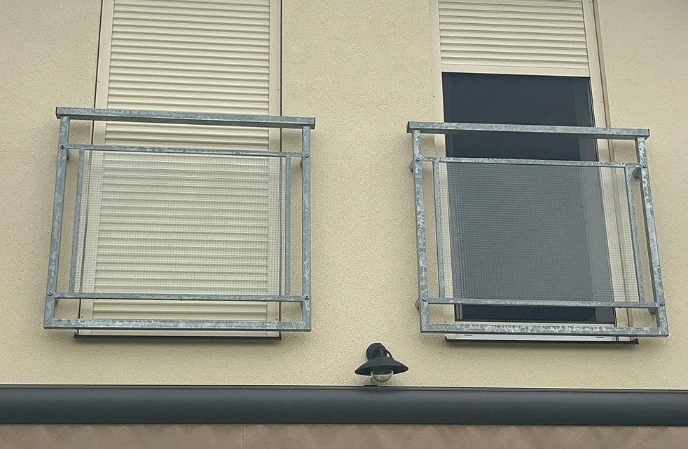 „Venkovní předokenní rolety instalované na fasádě domu, ilustrující jejich designovou eleganci a funkční ochranu proti slunci a hluku.“