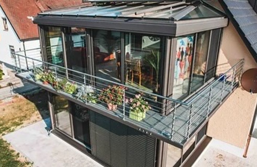 Elegantní zimní zahrada s hliníkovou konstrukcí a skleněnou střechou od Hezký stín rozšiřuje obytný prostor o celoroční místo pro relax i výhled do zahrady.