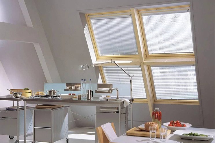 Střešní okna s žaluziemi v bílém pokoji