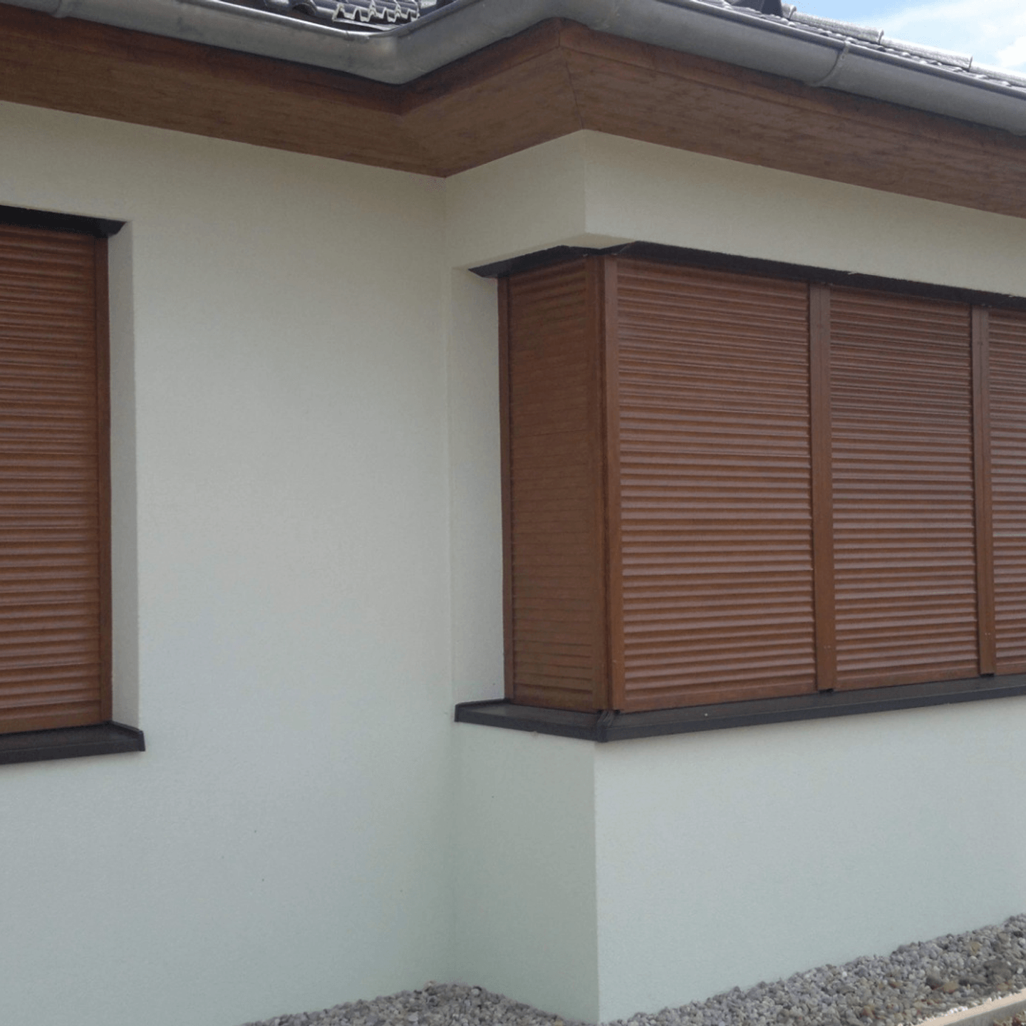 Hnědé venkovní rolety na oknech rodinného domu