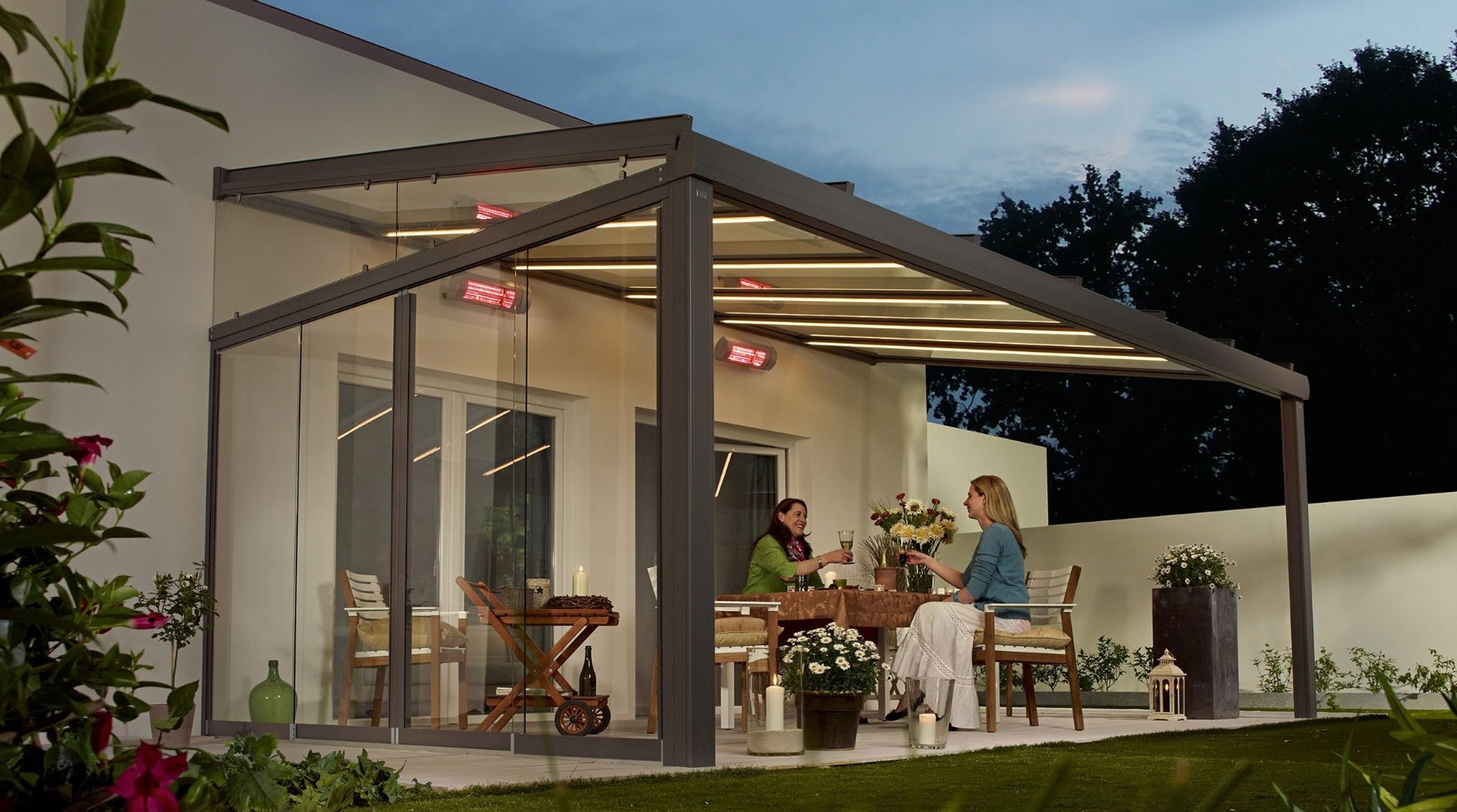 Ženy s vínem sedící pod zastřešenou pergolou