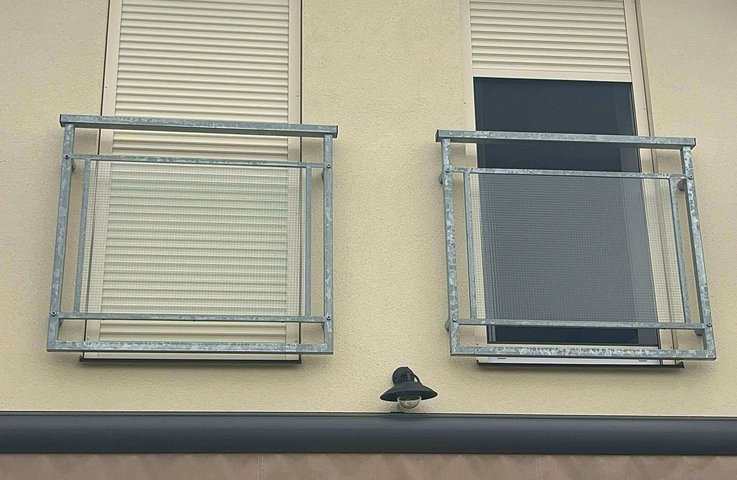 „Venkovní předokenní rolety instalované na fasádě domu, ilustrující jejich designovou eleganci a funkční ochranu proti slunci a hluku.“