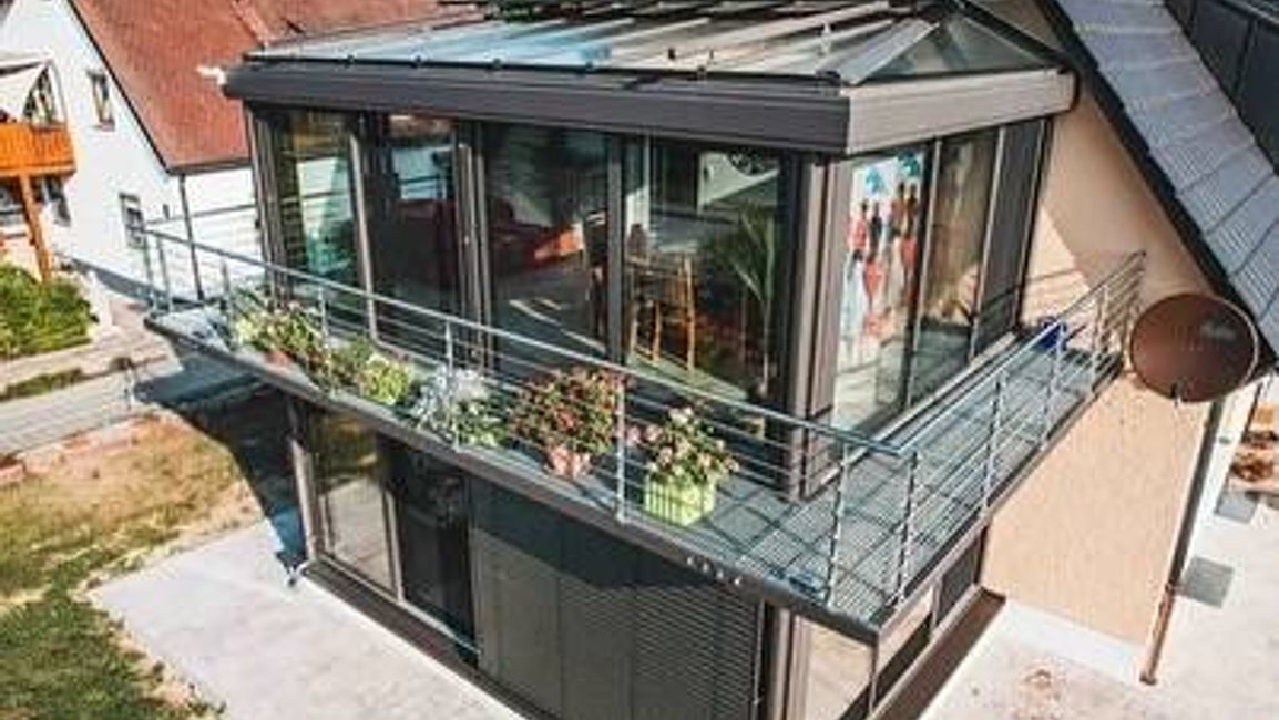 Elegantní zimní zahrada s hliníkovou konstrukcí a skleněnou střechou od Hezký stín rozšiřuje obytný prostor o celoroční místo pro relax i výhled do zahrady.