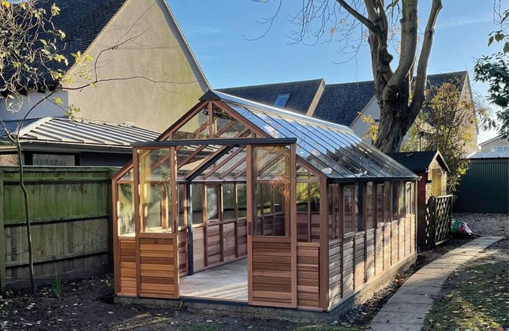 Elegantní dřevěný skleník s prosklenou střechou, který přináší do zahrady harmonii přírody a poskytuje ideální podmínky pro pěstování rostlin i odpočinek.