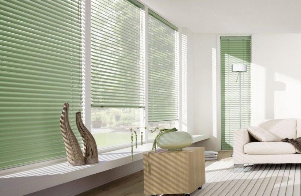 Stylové horizontální žaluzie v jemném zeleném odstínu doplňují světlý interiér a poskytují dokonalou kontrolu nad světlem i soukromím.