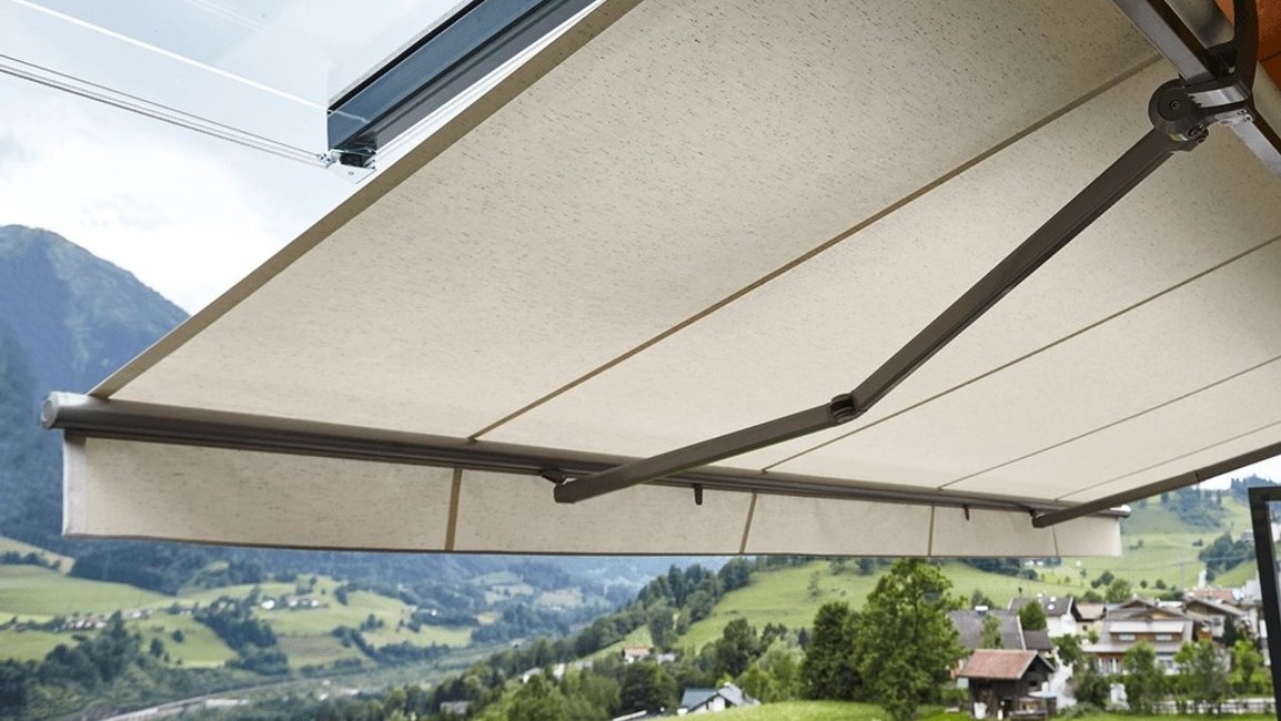 Moderní výsuvná markýza s horním krytem zastíní terasu rodinného domu a chrání látku před deštěm i nečistotami. Díky velkému výsuvu vzniká pohodlné místo pro venkovní stolování s krásným výhledem do okolní krajiny
