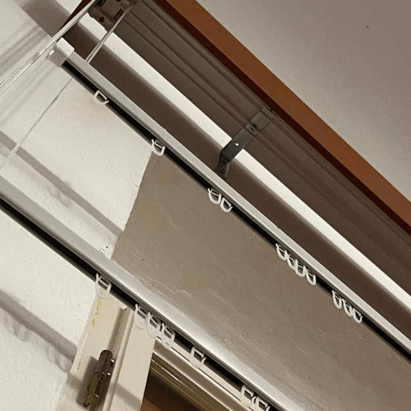 Spouštěcí garnýže u okna v činžovním bytě