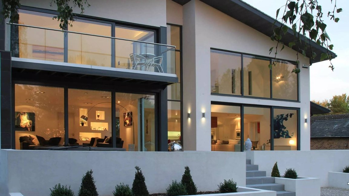 Velkoformátová hliníková okna a posuvné dveře přinášejí do interiéru maximální světlo a propojují dům se zahradou. Estetické, odolné a nadčasové řešení od Hezký stín.