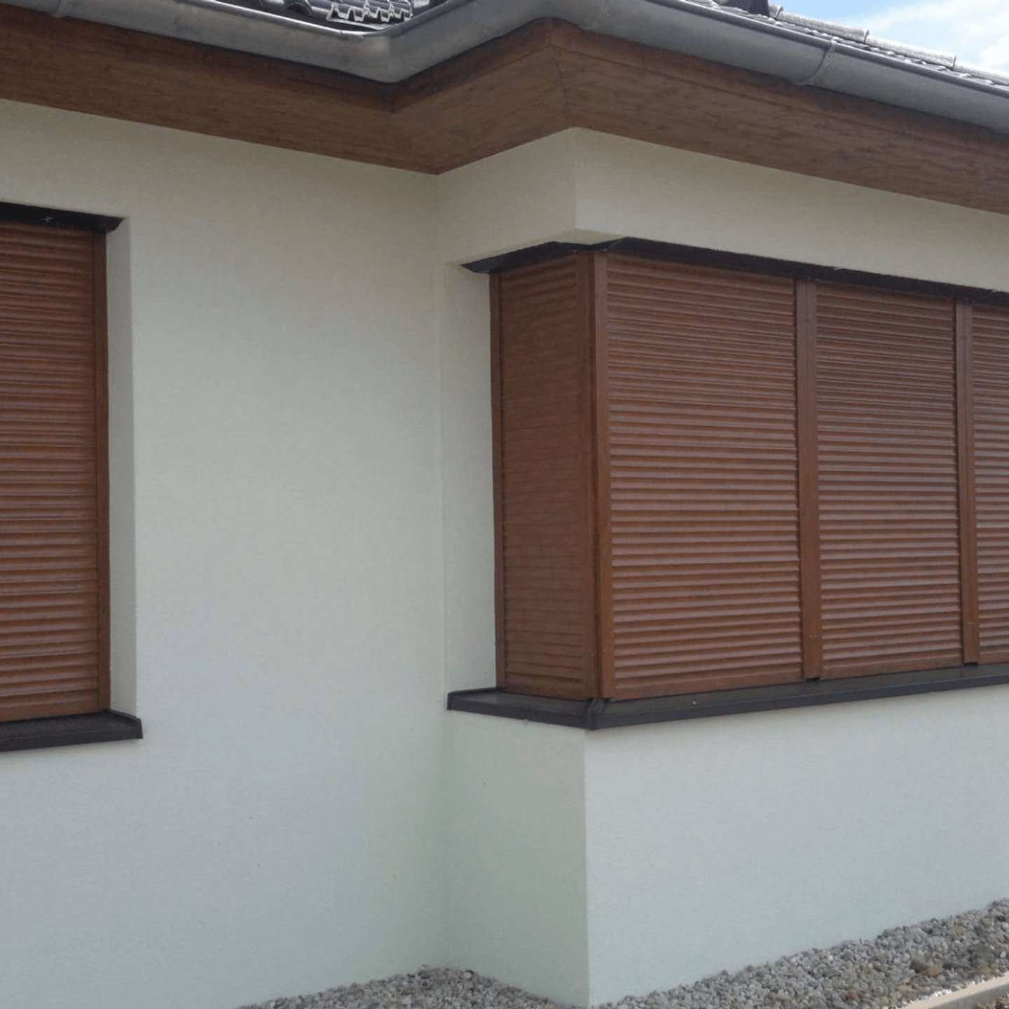 Hnědé venkovní rolety na oknech rodinného domu